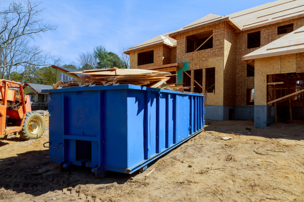 blue dumpster outside a house being constructed