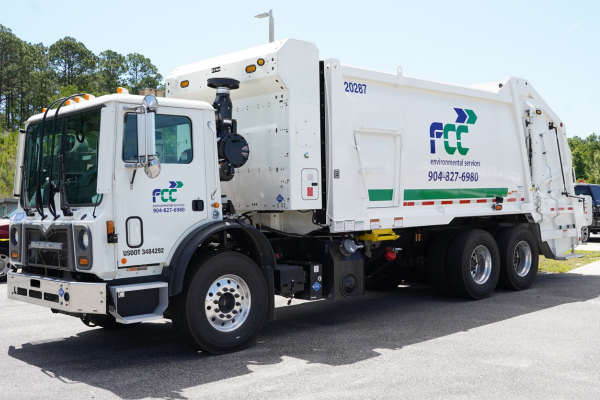 white FCC garbage truck parked in parking lot
