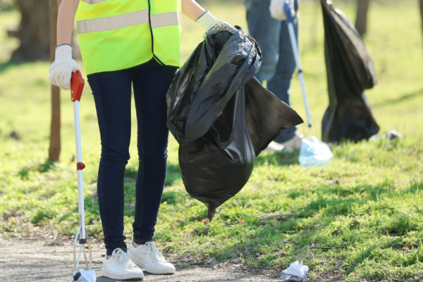 Volunteer picking up trash off trails and park lawns