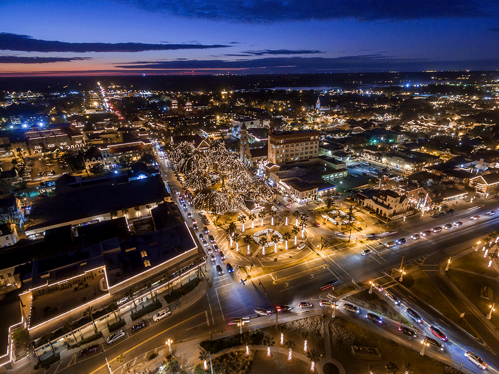 aerial sunset view of downtown St. Augustine during Nights of Lights showcasing lighted tress and businesses