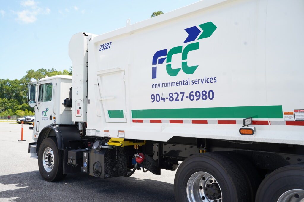 white FCC garbage truck