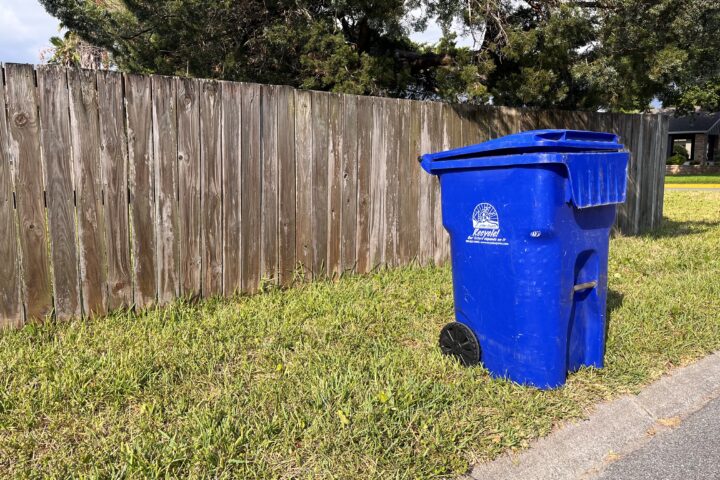 blue recycling cart at the curb