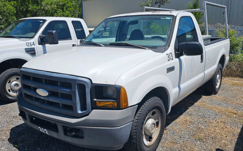 front and side view of older white work truck