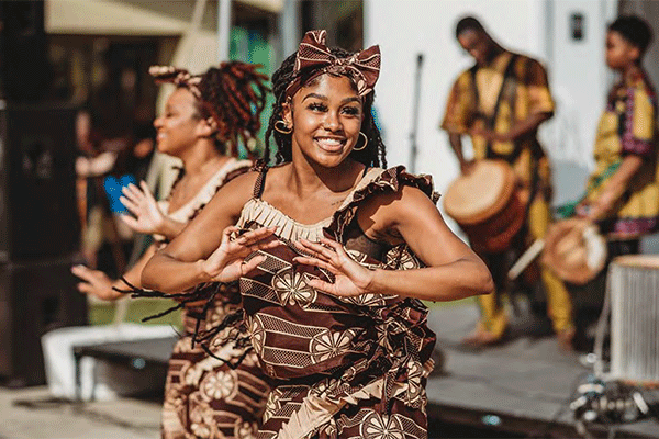 Smiling dancer in traditional African attire performing