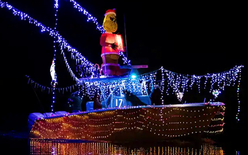 Boat decorated with lights reflecting in water at night