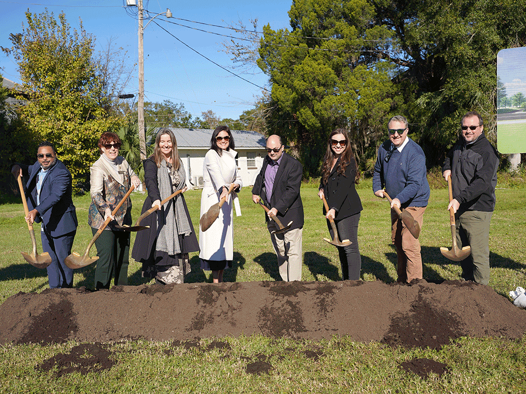 Commissioner Sarah Arnold, Library Director Deborah Gibson, and other community members dig using shovels for the Hastings Library groundbreaking ceremony.