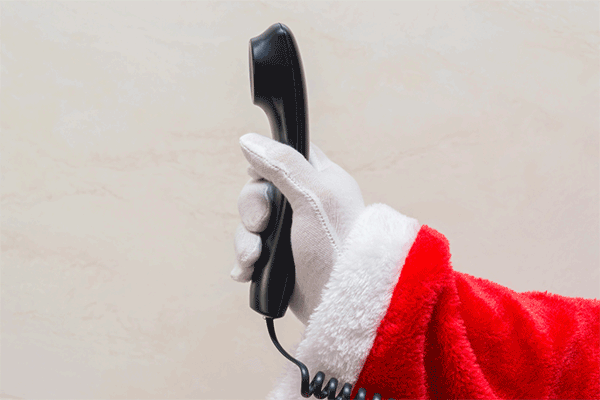 A gloved hand holds out a wired telephone