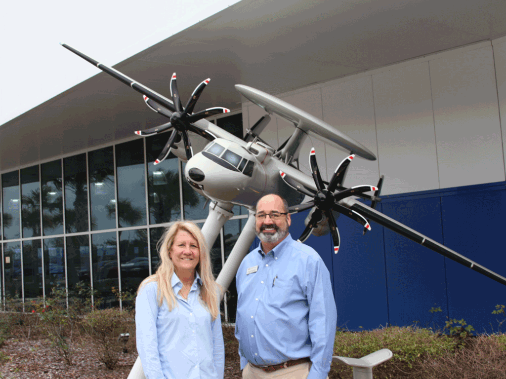 Commissioner Joseph and Chamber of Commerce Scott Maynard in front of a model plane.