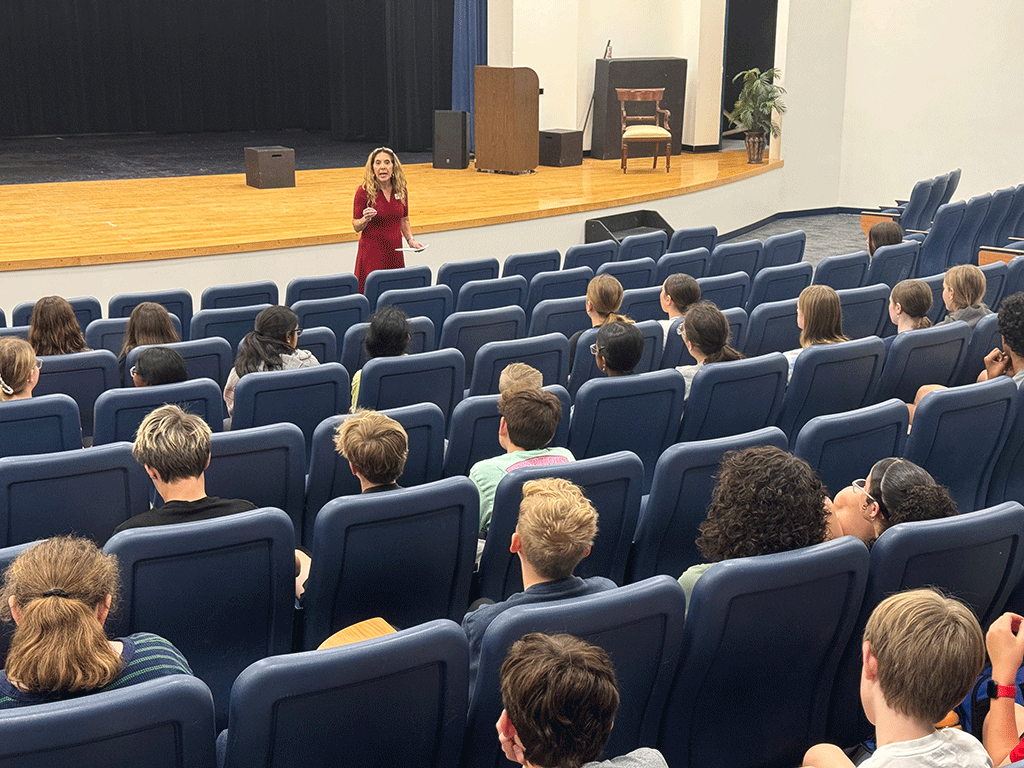 Commissioner Ann Taylor speaks to students in auditorium